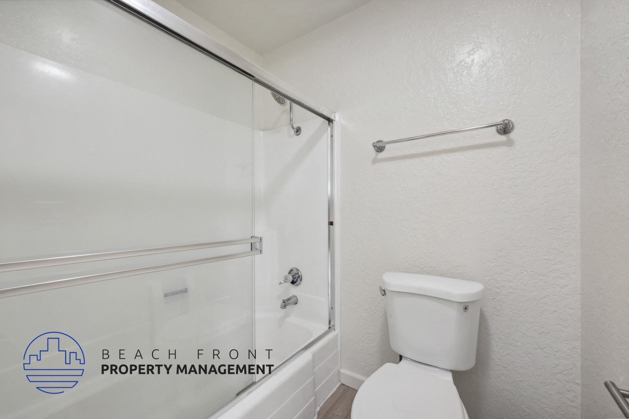 A white toilet in a bathroom with a glass shower door.